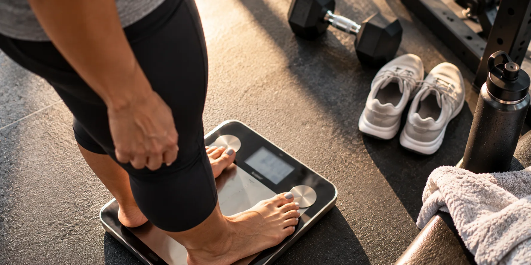 Person stepping onto body composition scale for body fat percentage testing as part of Miami weight loss program